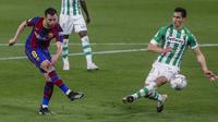 Gelandang Barcelona, Miralem Pjanic menembak bola dari kawalan pemain Real Betis, Aissa Mandi pada lanjutan La Liga Spanyol di stadion Benito Villamarin di Seville, Spanyol, Senin (8/2/2021).  Kemenangan ini membuat Barcelona berada di posisi dua pada klasemen. (AP Photo/Miguel Morenatti)