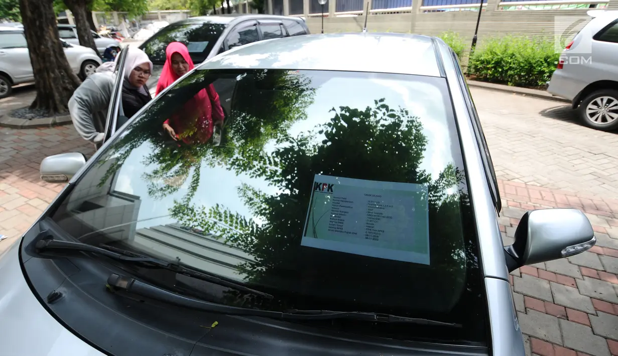 Warga mengecek kondisi mobil operasional KPK yang akan dilelang di Gedung KPK Lama, Jakarta, Selasa (27/2). KPK bakal menggelar lelang barang inventaris pada Kamis (1/3/2018) mulai pukul 10.00 WIB sampai dengan selesai. (Liputan6.com/Helmi Fithriansyah)