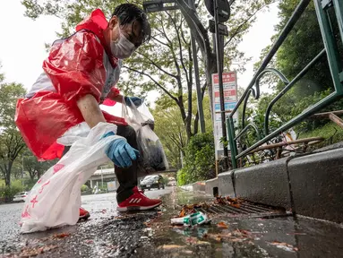 Seorang peserta memungut sampah dari jalan selama tahap Jepang "SpoGOMI World Cup 2023" di mana para tim memungut sampah sebanyak mungkin, di daerah Shinjuku, Tokyo pada tanggal 9 Oktober 2023. (Richard A. Brooks/AFP)