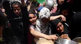 Warga Palestina berjuang untuk mendapatkan jatah makanan mereka di luar pusat distribusi di Beit Lahia, Jalur Gaza Utara pada 15 Mei 2025. (BASHAR TALEB/AFP)