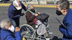 Seorang wanita di kursi roda tiba untuk disuntik dosis ketiga vaksin COVID-19 AstraZeneca di Centro de Estudios Superiores Navales (CENCIS) di Mexico City, Selasa (7/12/2021). Ibu kota Meksiko pada hari Selasa mulai memberikan vaksinasi booster bagi yang berusia di atas 60 tahun. (Pedro PARDO/AFP)