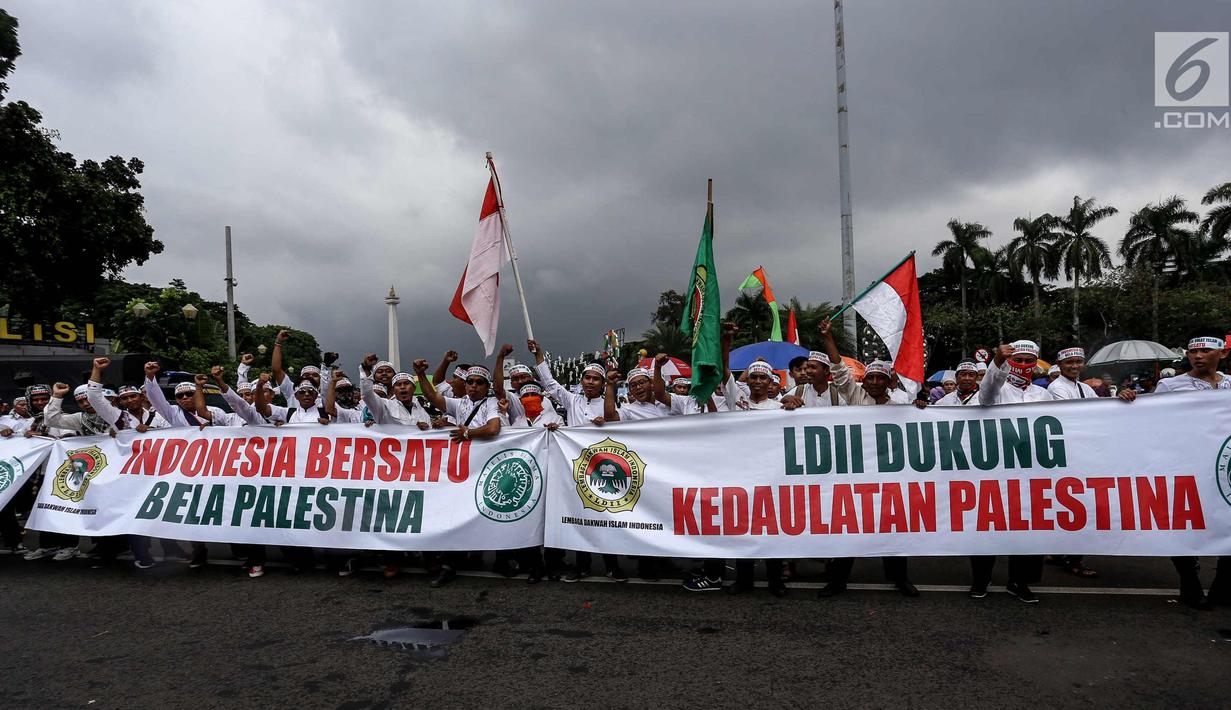 Peserta Aksi Bela Palestina membentangkan spanduk saat unjuk rasa di kawasan silang Monas, Jakarta, Minggu (17/12). MUI memimpin aksi protes keputusan Presiden AS, Donald Trump yang mengakui Yerusalem sebagai ibu kota Israel. (Liputan6.com/Faizal Fanani)