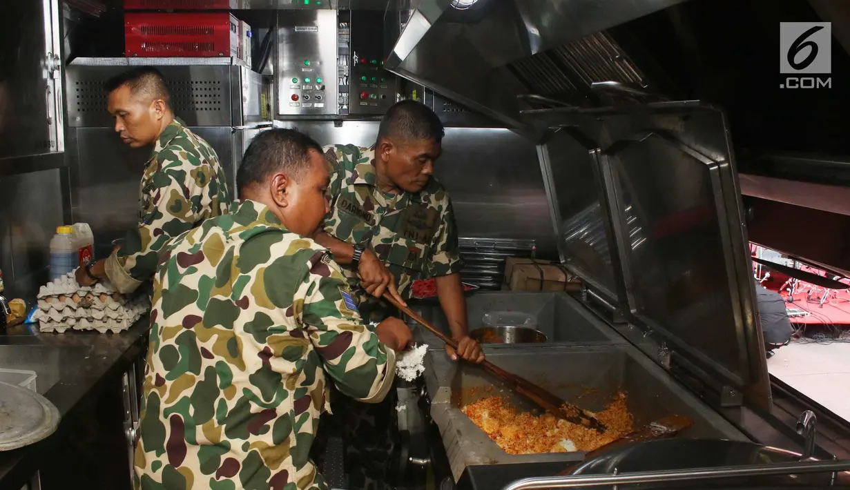 Prajurit Korps Marinir TNI AL mengolah nasi goreng yang akan dibagikan ke warga saat car free day di Jakarta, Minggu (5/11). Kegiatan bagi-bagi nasi goreng ini dalam rangka menyambut HUT Marinir ke-72. (Liputan6.com/Angga Yuniar)