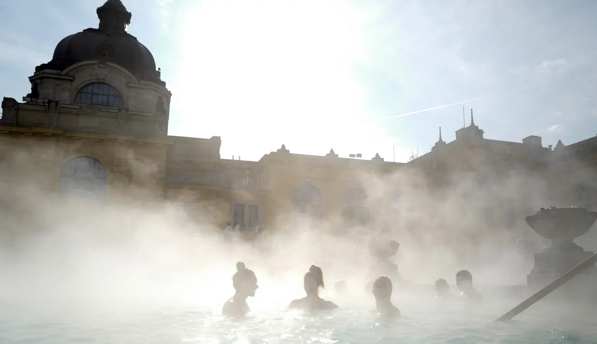 Para pengunjung berbincang sambil berendam di kolam relaksasi Szechenyi, di Budapest, Hongaria pada 15 Februari 2019. Szechenyi Thermal Bath adalah salah satu lokasi pemandian umum tertua dan terbesar di Budapest. (VALERY HACHE / AFP)