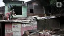 Warga membersihkan sampah yang memenuhi rumah akibat terbawa arus banjir di kawasan Rawajati, Jakarta, Minggu (5/1/2020). Puluhan rumah warga yang berada di bantaran Kali Ciliwung itu mengalami kerusakan parah dan dipenuhi sampah serta lumpur akibat terjangan banjir. (merdeka.com/Iqbal Nugroho)