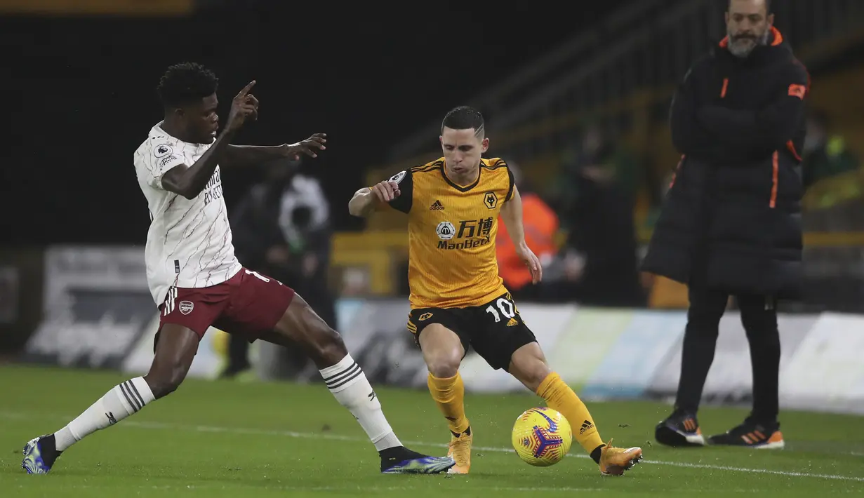 Gelandang Wolverhampton Wanderers, Daniel Podence berebut bola dengan gelandang Arsenal, Thomas Partey pada pekan ke-22 Liga Inggris di stadion Mollineux, Rabu (3/2/2021) dini hari WIB. Arsenal harus pulang dengan tangan hampa usai kalah 1-2 atas Wolverhampton. (Nick Potts/Pool via AP)
