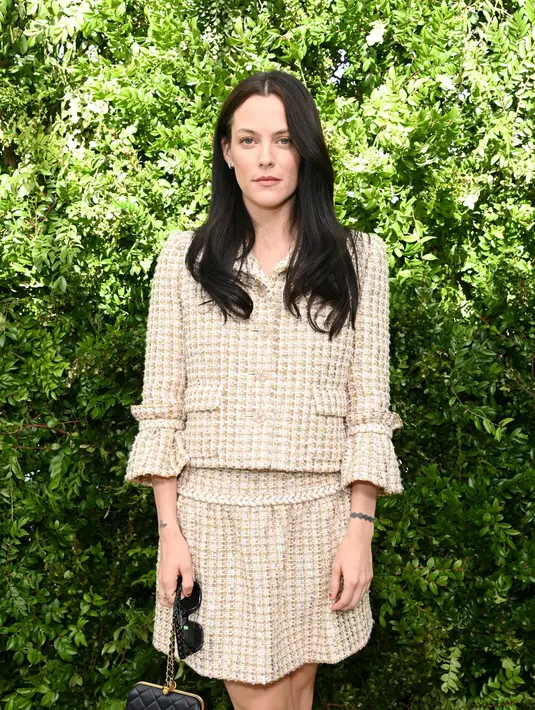 Riley Keough, cucu dari Raja Rock and Roll Elvis Presley, tampil cantik dalam balutan cropped tweed jacket dengan rok berwarna senada. [Dok/Chanel]