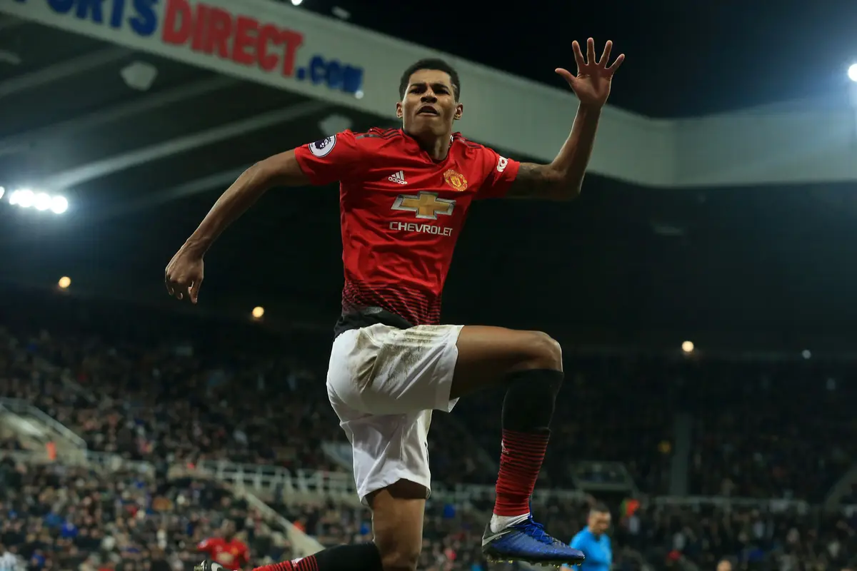 Striker Manchester United, Marcus Rashford, merayakan gol yang dicetaknya ke gawang Newcastle pada laga Premier League di Stadion St James Park, Newcastle, Rabu (2/1). Newcastle kalah 0-2 dari MU. (AFP/Lindsey Parnaby)