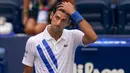 Reaksi petenis Serbia, Novak Djokovic setelah tidak sengaja memukulkan bola ke hakim garis saat kehilangan poin dari Pablo Carreno Busta (Spanyol) pada putaran keempat US Open 2020, di Flushing Meadows, Minggu (6/9/2020). Djokovic pun didiskualifikasi dari AS Terbuka 2020. (AP Photo/Seth Wenig)