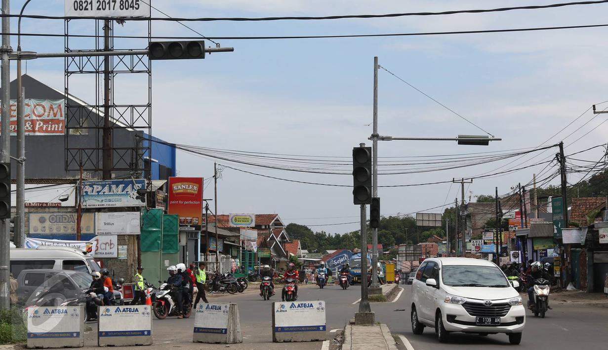 Kendaraan melintas di pertigaan Jatinangor, Sumedang, Jawa Barat, Sabtu (2/7). Mengatasi kepadatan kendaraan pemudik, petugas melakukan sistem pengalihan arus dengan menutup jalur dari arah Sumedang menuju Bandung Kota. (Liputan6.com/Immanuel Antonius)