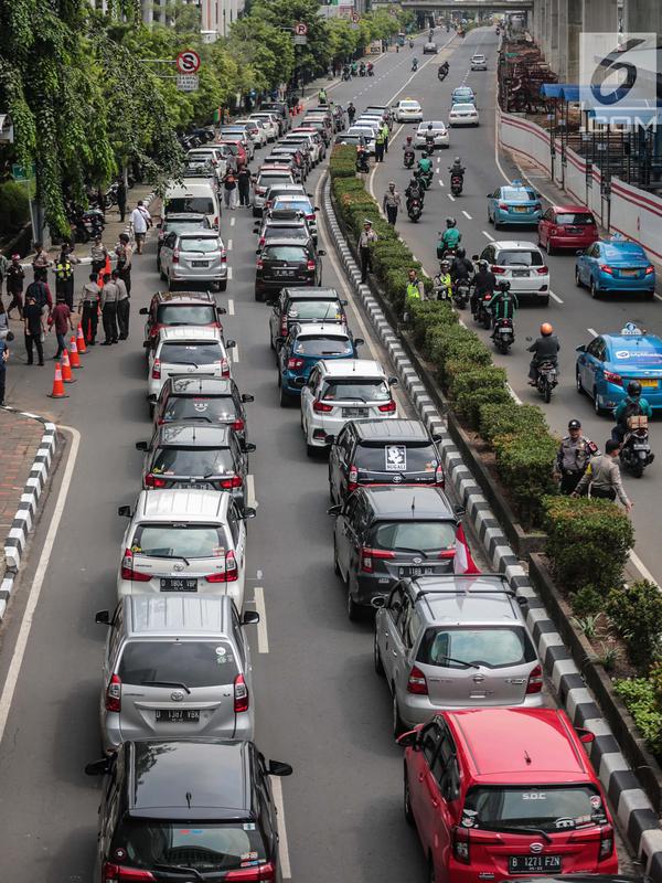 Kendaraan melintas dekat mobil pengemudi online yang menutup jalur lambat saat demonstrasi di kantor pusat Grab kawasan Kuningan, Jakarta, Senin (29/10). Aksi tersebut menyebabkan kemacaten dari arah Mampang menuju Menteng. (Liputan6.com/Faizal Fanani)