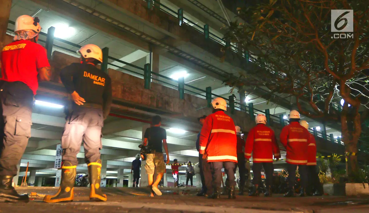 Petugas pemadam kebakaran berada di reruntuhan bangunan parkir bertingkat akibat gempa di Mal Galeria, Ngurah Rai, Bali, Minggu malam (5/8). Gempa di Lombok Utara mengakibatkan kendaraan bermotor tertimbun reruntuhan bangunan. (Liputan6.com/Johan Tallo)
