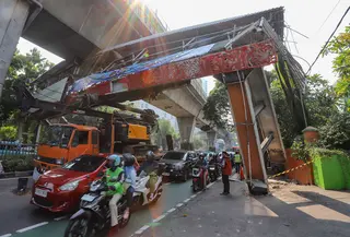 Sebuah truk  truk towing pengangkut alat berat (crane)  tersangkut dan merusak  jembatan penyeberangan orang (JPO) di Jalan Raya Kapten Tendean, Jakarta, Selasa (14/07/2026).