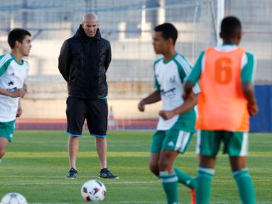 Pelatih Real Madrid Zinedine Zidane memperhatikan para pemain bola U14 dari tim Canton de Vaud, Lausanne, Senin (3/10). Zidane memimpin sesi latihan untuk seleksi tim Swiss, U14 Canton de Vaud. (REUTERS/Denis Balibouse) 