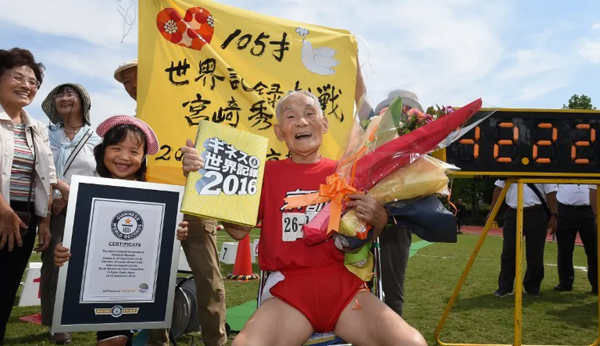Hidekichi Miyazaki bersama anak dan cucunya setelah dinobatkan sebagai sprinter tertua di dunia oleh Guinness World Records saat berlomba di nomor lari 100m Kyoto Masters Autumn Competiton di Kyoto, Jepang, Rabu (23/9/2015). (AFP Photo/Toru Yamanaka)
