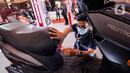 Pekerja memeriksa sepeda motor listrik yang dipamerkan pada pembukaan Indonesia Motorcycle Show (IMOS) 2022 di Jakarta Convention Center (JCC), Jakarta, Rabu (2/11/2022). IMOS 2022 memamerkan produk dan teknologi terkini industri sepeda motor Indonesia serta berbagai perlengkapan otomotif lainnya. (Liputan6.com/Johan Tallo)