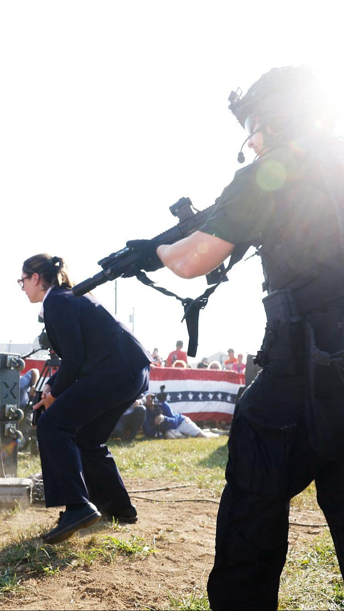 Mereka bergegas memberikan perlindungan ketat kepada Donald Trump yang berada di mimbar kampanye.&nbsp;Foto: AFP