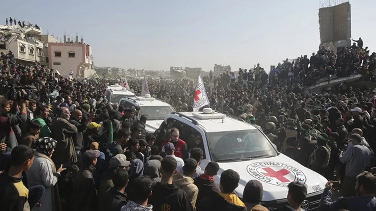 Kerumunan orang mengelilingi mobil Palang Merah saat mereka tiba di lokasi penyerahan sandera oleh Hamas di Khan Younis, Gaza Selatan, Kamis (30/1/2025).
