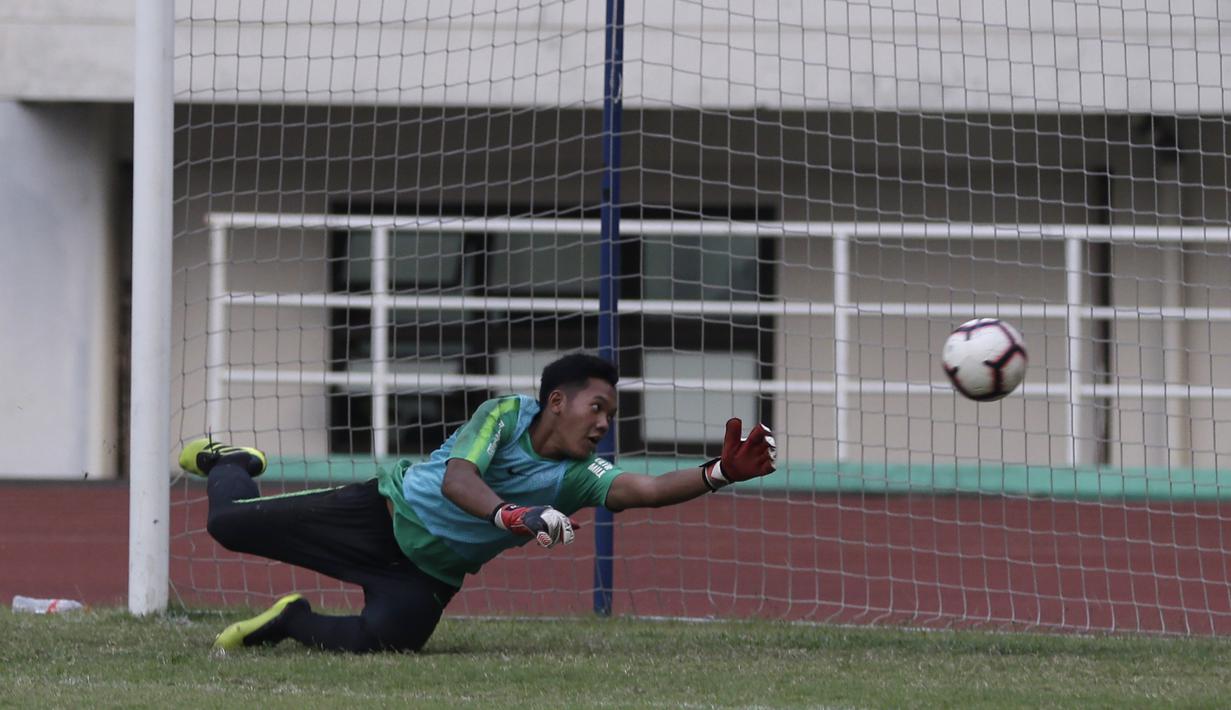 Kiper Timnas Indonesia U-19, Muhammad Risky, berusaha menepis bola saat latihan di Stadion Pakansari, Bogor, Rabu (2/10). Latihan ini merupakan persiapan jelang AFF U-19 di Vietnam. (Bola.com/Yoppy Renato)