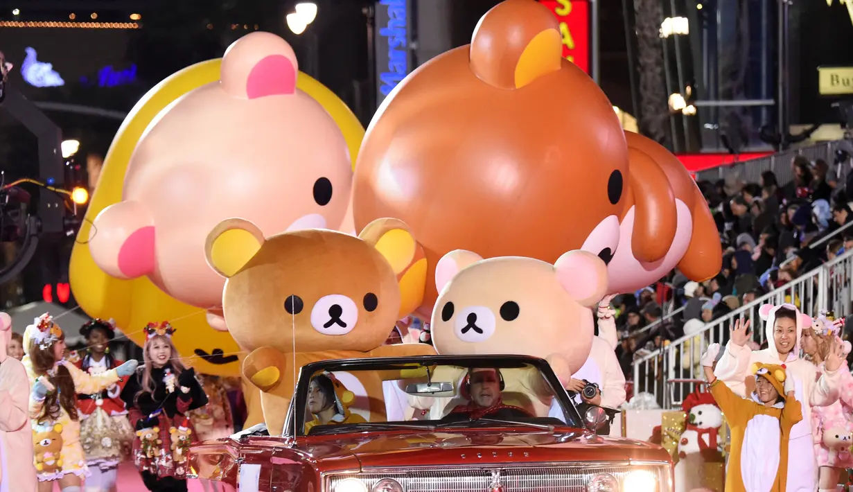 Peserta mengenakan kostum dan membawa balon udara karakter Jepang Rilakkuma dan Korilakkuma saat mengikuti Parade Natal Hollywood ke-85 di Los Angeles, California, AS (27/11). (Reuters/Phil McCarten)