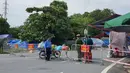 Polisi berjaga di belakang barikade yang didirikan untuk mengatur lalu lintas di Hanoi, Sabtu (24/7/2021). Vietnam memberlakukan penguncian wilayah (lockdown) selama 15 hari di ibu kota Hanoi mulai Sabtu ketika gelombang virus corona menyebar dari wilayah Delta Mekong selatan. (AP Photo/Hieu Dinh)