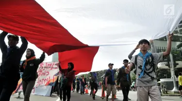 Komunitas Mahasiswa Pecinta Alam (Mapala) se-Jabodetabeka membentangkan bendera Merah Putih raksasa saat memperingati Hari Bumi di CFD Bundaran HI, Jakarta, Minggu (21/4). Aksi ini untuk memperingati Hari Bumi yang jatuh pada 22 April. (merdeka.com/Iqbal Nugroho)