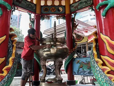 Seorang warga keturunan Tionghoa melakukan ritual bersih-bersih di Vihara Amurva Bhumi, Jakarta, Sabtu (14/1/2022). Tradisi ini rutin dilakukan jelang perayaan Tahun Baru Imlek. (Liputan6.com/Johan Tallo)