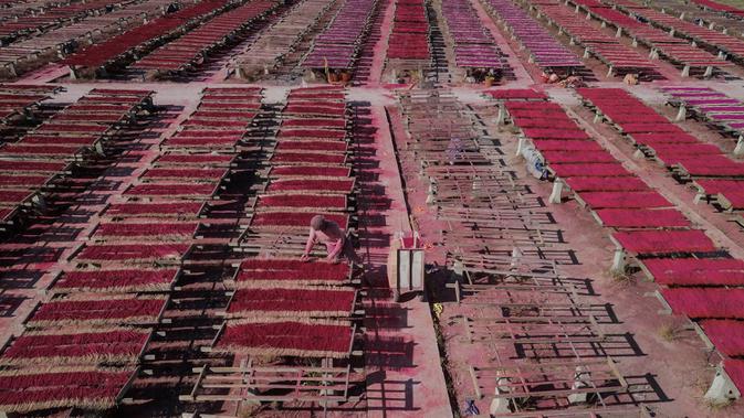 Gambar udara pada 11 Desember 2019, pekerja menata dupa-dupa untuk dikeringkan di Pabrik Dupa Fujian Xingquan, Provinsi Fujian, China. Mendekati liburan Tahun Baru Imlek, ini adalah waktu yang penting tahun bagi penduduk desa ini yang memasok banyak dupa dunia. (HECTOR RETAMAL/AFP)