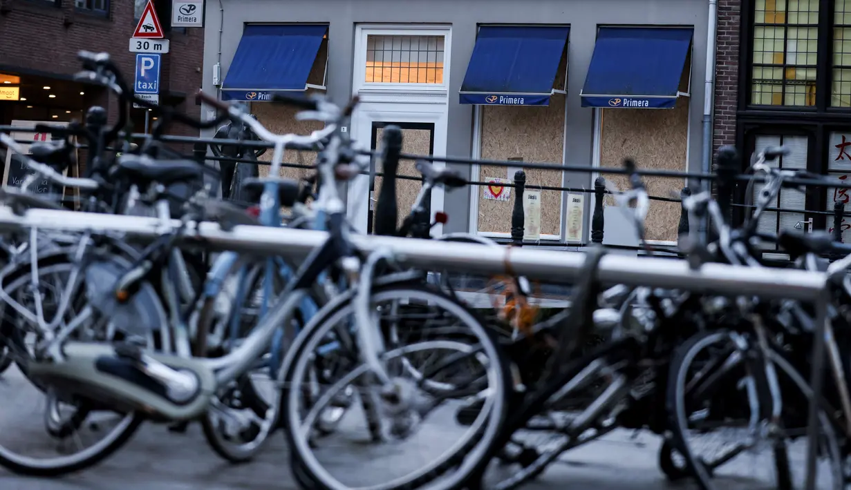 Toko yang tertutup papan sehari setelah polisi bentrok dengan sekelompok demonstran yang memprotes pemberlakuan jam malam akibat virus corona di Den Bosch, Belanda (26/1/2021). (AFP/Kenzo Tribouillard)