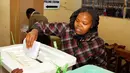 Wanita Kenya memasukkan kertas suara ke dalam kotak usai menggunakan hak pilihnya di sebuah TPS di Nairobi, Selasa (8/8). Negara berpenduduk 50 juta jiwa itu antusias berpartisipasi dalam Pemilihan Umum Presiden baru. (AP Photo/Khalil Senosi)