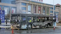 Petugas pemadam kebakaran saat memeriksa isi dalam bus usai hangus terbakar di sebuah jalan di Yinchuan, China, (5/1). 14 orang tewas dan 30 lainnya terluka akibat peristiwa ini. (REUTERS / Stringer)