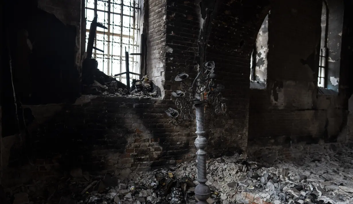 <p>Tempat lilin berdiri di dalam gereja yang rusak di Lukashivka, Ukraina utara, 22 April 2022. Penduduk mengatakan tentara Rusia menggunakan rumah ibadah untuk menyimpan amunisi, dan pasukan Ukraina menembaki gedung itu untuk membuat Rusia pergi. (AP Photo/Petros Giannakouris)</p>