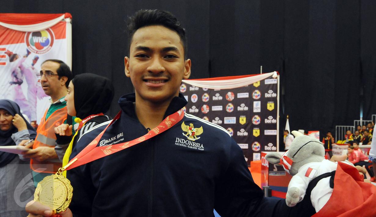 Ahmad Zigi Zaresta memamerkan medali yang diperoleh di nomor Junior Kata Male di WKF World Junior, Cadet and U-21 Championship 2015 di ICE Serpong, Banten, Kamis (12/11/2015). Zigi menyumbang emas pertama bagi Indonesia. (Liputan6.com/Helmi Fithriansyah)