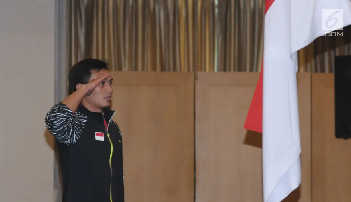 Pebulutangkis putera Indonesia untuk Thomas Cup 2018, M Ahsan melakukan penghormatan bendera saat upacara pelepasan di Jakarta, Selasa (8/5). Turnamen Piala Thomas dan Uber 2018 berlangsung di Bangkok, 20-27 Mei. (Liputan6.com/Helmi Fithriansyah)