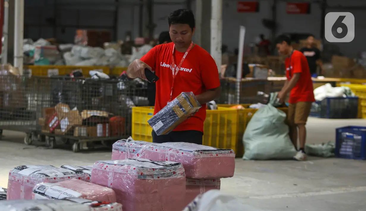 Pekerja menyortir paket yang akan dikirim ke berbagai kota di Mega Hub Lion Parcel, Kota Tangerang, Banten, Rabu (18/12/2024). (Liputan6.com/Angga Yuniar)