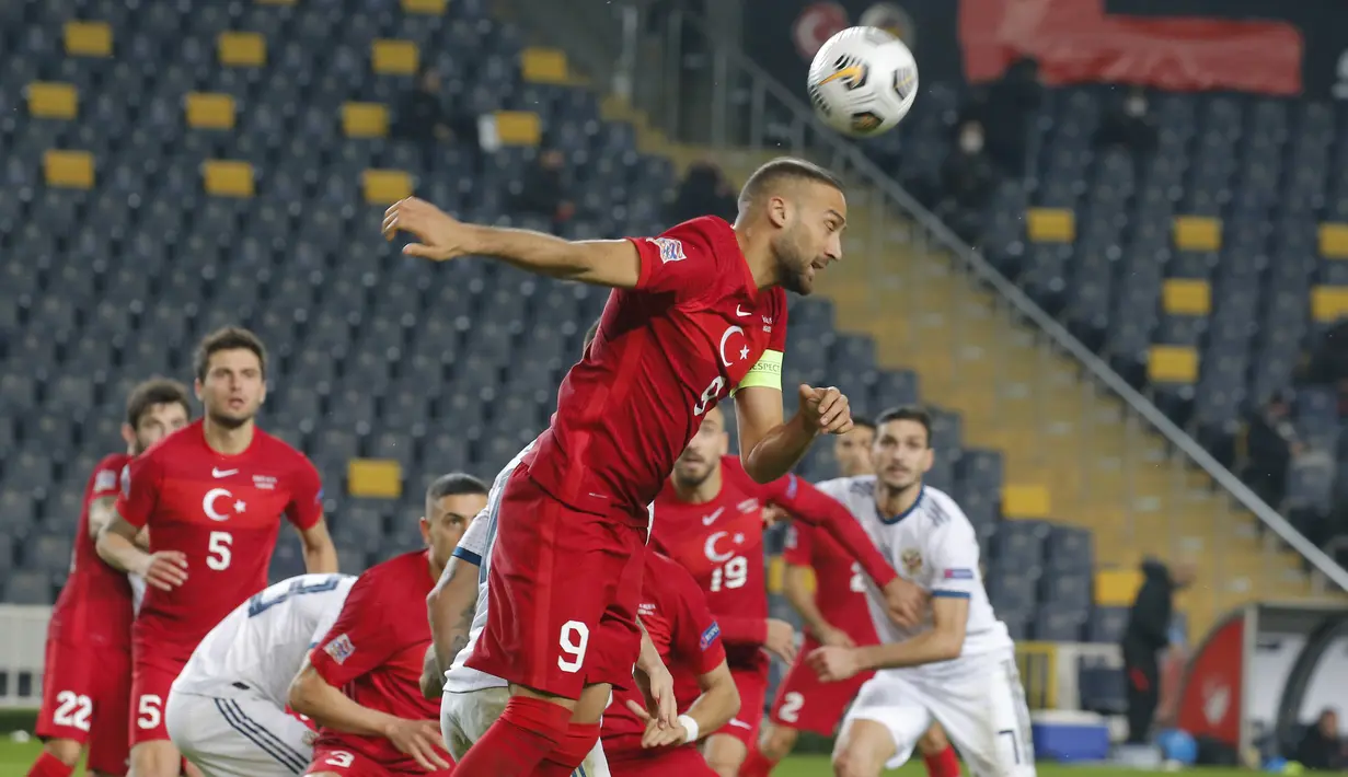 Penyerang Turki, Cenk Tosun menyundul bola saat bertanding melawan Rusia pada pertandingan UEFA Nations League di Stadion Sukru Saracoglu, Istanbul, Minggu (15/11/2020). Turki menang tipis atas Rusia 3-2. (AP Photo)
