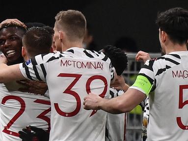Gelandang Manchester United, Paul Pogba (kiri) bersama rekan setim merayakan gol yang dicetaknya ke gawang AC Milan dalam laga leg kedua babak 16 besar Liga Europa 2020/2021 di San Siro Stadium, Milan, Kamis (18/3/2021). Manchester United menang 1-0 atas AC Milan. (AFP/Marco Bertorello)