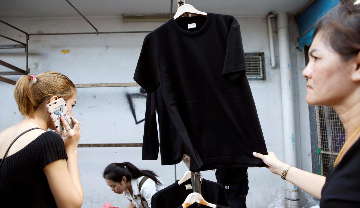 Warga membeli T-shirt hitam untuk acara berkabung atas meninggalnya Raja Thailand Bhumibol Adulyadej di Pasar Grosir Bo Bae Bangkok, Thailand (15/10). (REUTERS / Edgar Su)