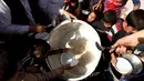 Sejumlah Warga berebut makanan saat mengungsi di kamp Khazer, Irak, (11/11). Warga terpaksa melarikan diri saat Pasukan Irak dan kelompok militan ISIS bentrok memberebutkan kota Mosul. (REUTERS/Zohra Bensemra)