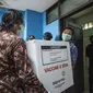 Pekerja menurunkan vaksin COVID-19 produksi Sinovac dari truk pengawalan polisi di Surabaya pada Senin (4/1/2021).  Pemerintah mulai mendistribusikan 3 juta dosis vaksin Covid-19 asal perusahaan China, Sinovac, ke 34 provinsi Indonesia. (Photo by Juni Kriswanto / AFP)