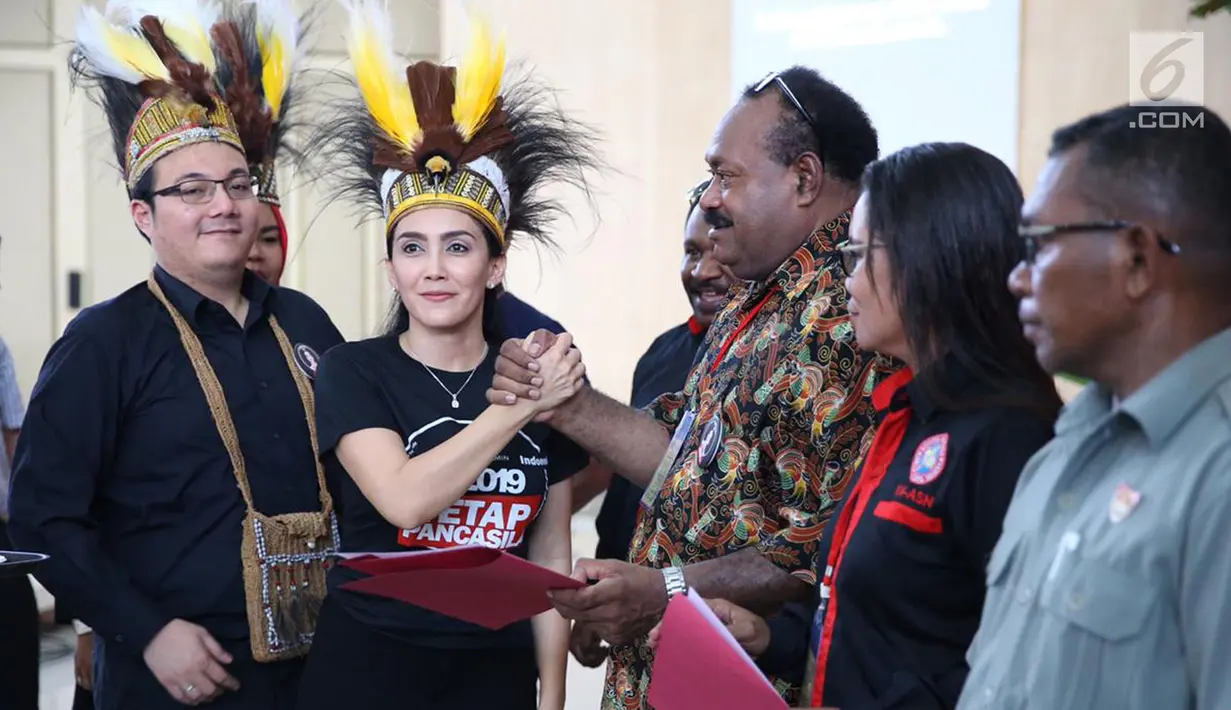Ketua Nasional Tim Alpha Relawan Capres dan Cawapres Jokowi-Ma'ruf Amin, Rieke Diah Pitaloka dan Seknas Tim Alpha Zona Papua, M.Herviano saat melantik relawan Tim Alpha Zona Papua di Kota Timika, Jumat (26/10). (Liputan6.com/Pool/Arif)