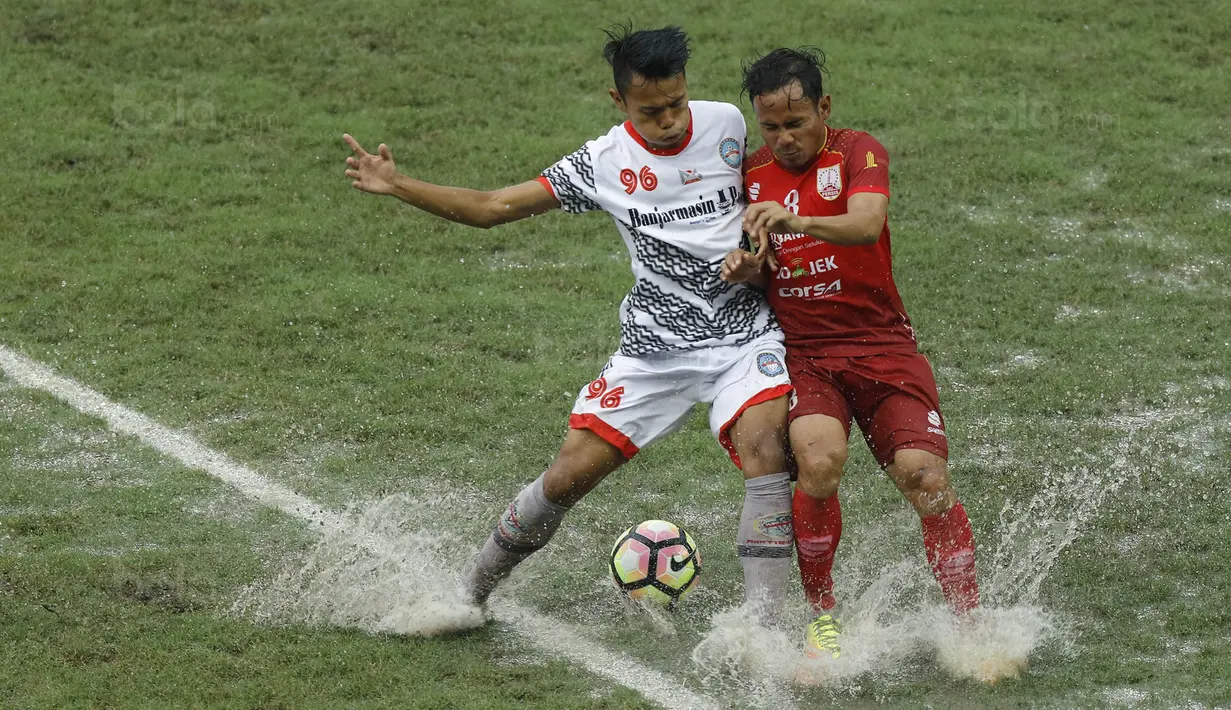 Gelandang Martapura FC, Reza Saputra, berebut bola dengan gelandang Persis Solo, Eli Nasoka, pada laga 8 besar Liga 2 Indonesia di Stadion Patriot, Bekasi, Kamis (9/11/2017). Persis kalah 0-1 dari Martapura FC. (Bola.com/M Iqbal Ichsan)