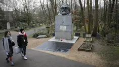 Pengunjung berjalan dekat makam filsuf ternama Jerman dan tokoh sosialisme, Karl Marx, di Pemakaman Highgate, London, Selasa (5/2). Nisan peringatan terbuat dari marmer yang menandakan persemayaman Marx dirusak oleh orang tidak dikenal. (Tolga AKMEN/AFP)