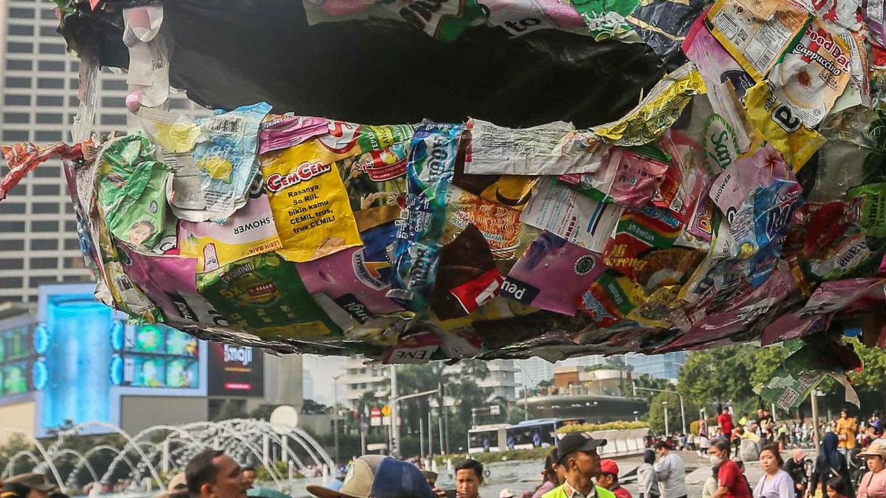 FOTO: Pegiat Lingkungan Pawai Bawa 'Ular Sampah Saset Raksasa' Tuntut Bebas Plastik di Kawasan Bundaran HI