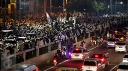 Massa peserta demo 4 November menduduki Jalan Gatot Subroto, Jakarta, atau tepat di depan Gedung MPR/DPR RI, Jumat (4/11). Mereka terpaksa menginap di jalan depan Gedung DPR lantaran tak diizinkan masuk ke dalam komplek parlemen (Liputan6.com/Johan Tallo)