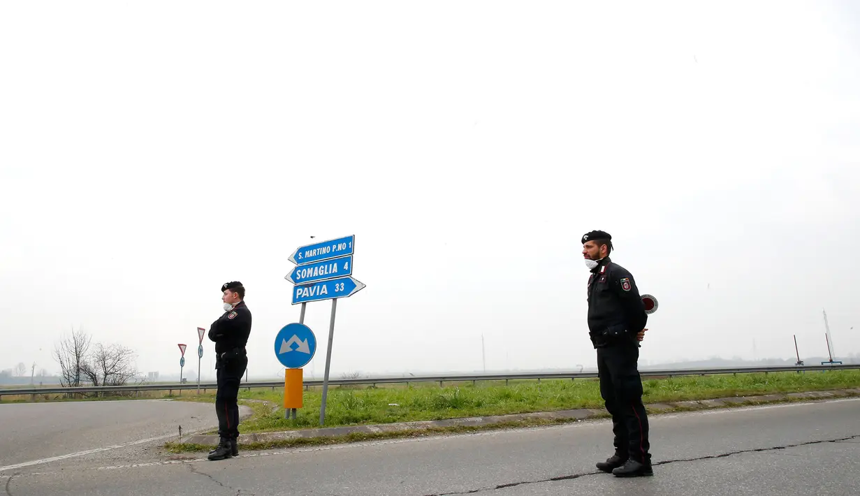 Polisi paramiliter memeriksa kendaraaan yang masuk dan keluar daerah yang dikunci terkait virus corona atau COVID-19 di Casalpusterlengo, Italia, Selasa (25/2/2020). Italia menjadi negara dengan kasus virus corona terbanyak di luar China dan benua Asia. (AP Photo/Antonio Calanni)