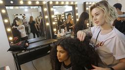 Model saat ditata rambutnya di belakang panggung sebelum tampil membawakan busana koleksi Beira selama Sao Paulo Fashion Week di Sao Paulo, Brasil (16/10/2019). SPFW ke-48 akan berlangsung hingga 18 Oktober.  (AP Photo / Nelson Antoine)