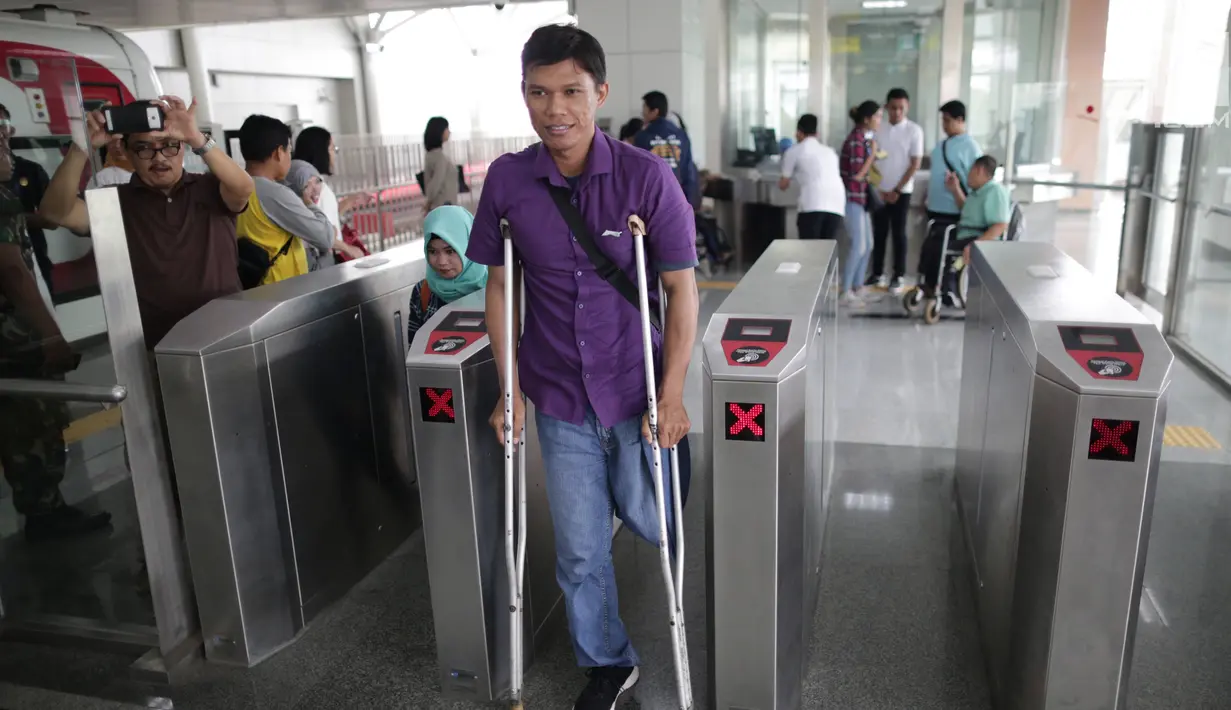 Seorang penyandang disabilitas melintasi "Gate Elektronik" di Stasiun LRT Veldrome, Jakarta, Sabtu (27/4). Kegiatan yang diikuti Jakarta Barrier Free Tourism (JBFT) tersebut untuk mengenalkan kereta Lintas Rel Terpadu (LRT)  lebih dekat kepada masyarakat. (Liputan6.com/Faizal Fanani)