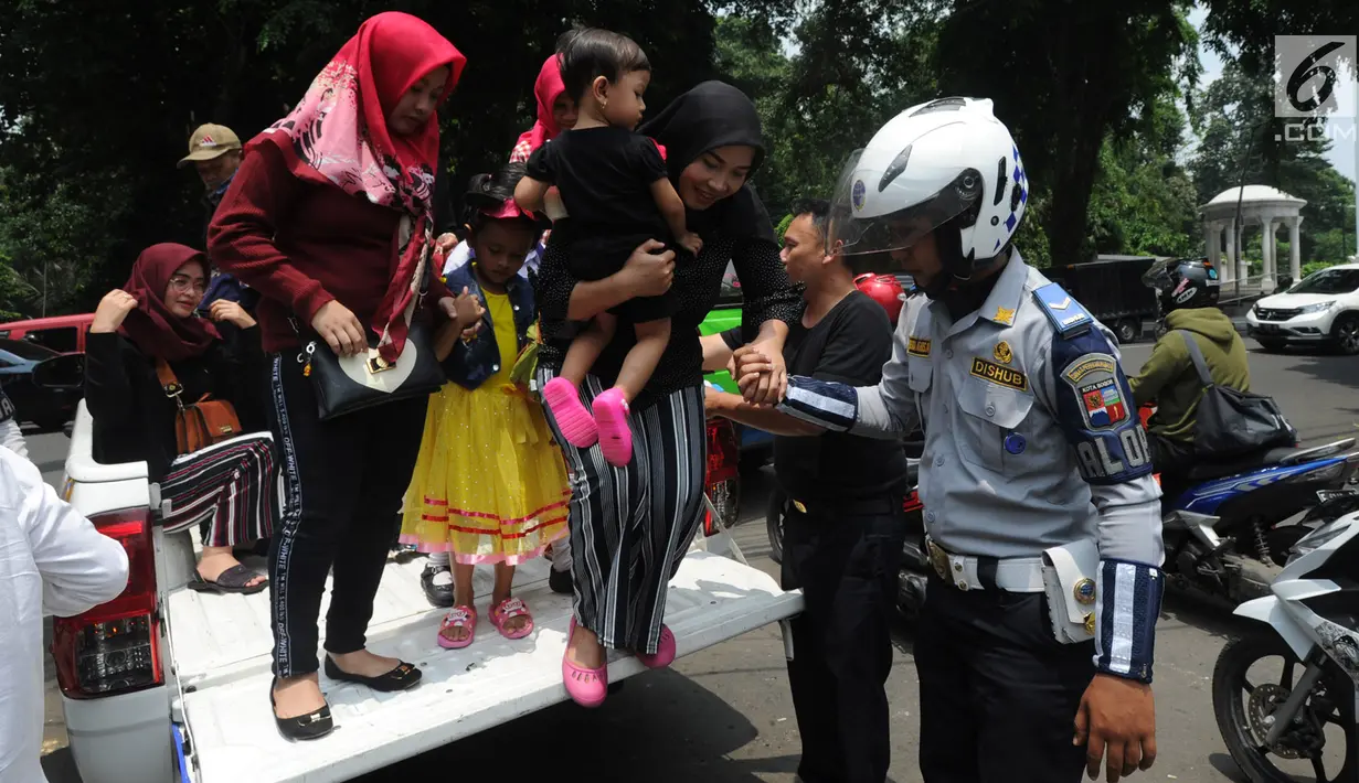 Warga menaiki mobil patroli Dinas Perhubungan Kota Bogor saat aksi mogok sopir angkot 08 dan 09 di kawasan Tugu Kujang, Selasa (13/11). Aksi mogok memprotes pengoperasian angkot modern itu membuat ratusan penumpang terlantar. (Merdeka.com/Arie Basuki)