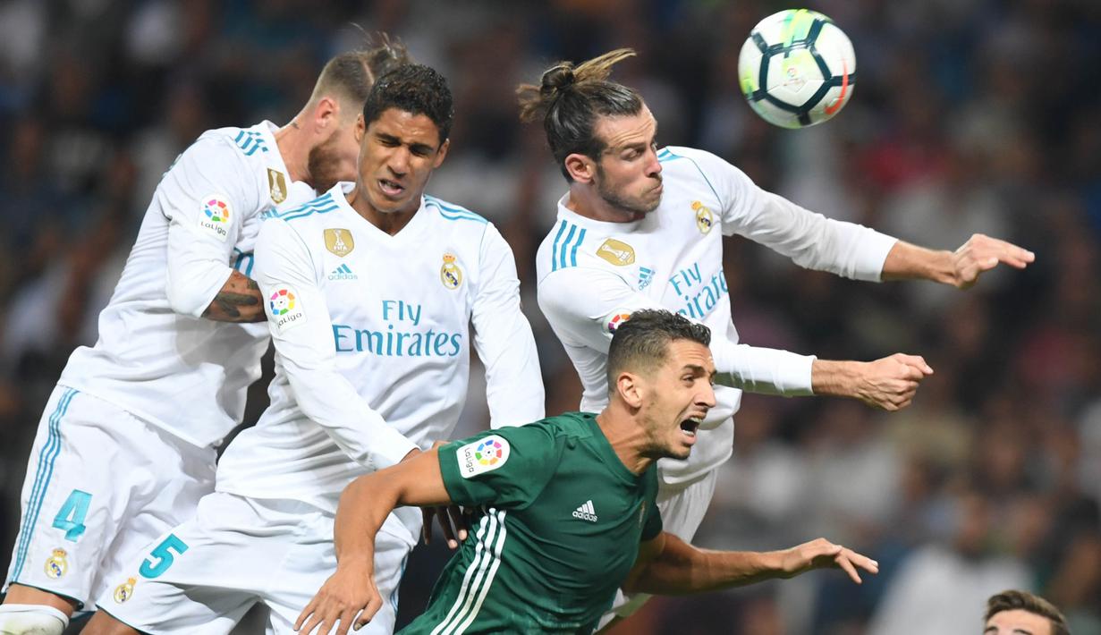 Pemain Real Madrid, Gareth Bale, duel udara dengan bek Real Betis, Morocco Zou, pada laga La Liga Spanyol di Stadion Santiago Bernabeu, Rabu (20/9/2017). Real Madrid kalah 0-1 dari Real Betis. (AFP/Gabriel Bouys)